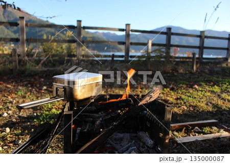 秋の河口湖畔で焚き火と飯盒炊飯を楽しむキャンプ風景 135000087