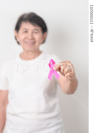 Elderly woman with pink Ribbon for Pink October Breast Cancer Awareness month, May Women Health, February World cancer day, support people life and illness. National cancer survivors month Elderly woman with pink Ribbon for Pink October Breast Cancer Awareness month, May Women Health, February World cancer day, support people life and illness. National cancer survivors month 135000201