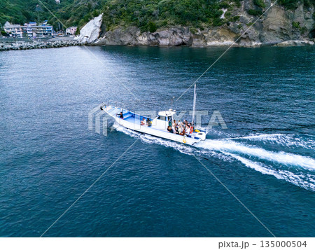 夕暮れのヒリゾ浜沖のドローン撮影。サンセットクルージングの漁船が航行している。ヒリゾ浜南伊豆町中木 135000504