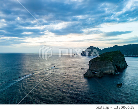 夕暮れのヒリゾ浜沖のドローン撮影。サンセットクルージングの漁船が航行している。ヒリゾ浜南伊豆町中木 135000519