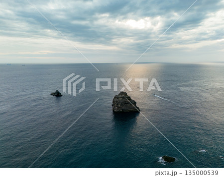夕暮れのヒリゾ浜沖のドローン撮影。サンセットクルージングの漁船が航行している。ヒリゾ浜南伊豆町中木 135000539