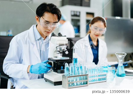 Scientists conducting medical research in a bright lab with microscopes and samples, representing healthcare innovation Scientists conducting medical research in a bright lab with microscopes and samples, representing healthcare innovation 135000639