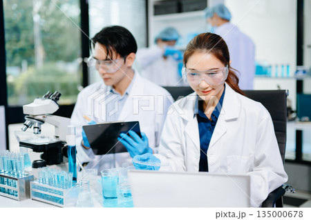 Scientists conducting medical research in a bright lab with microscopes and samples, representing healthcare innovation 135000678