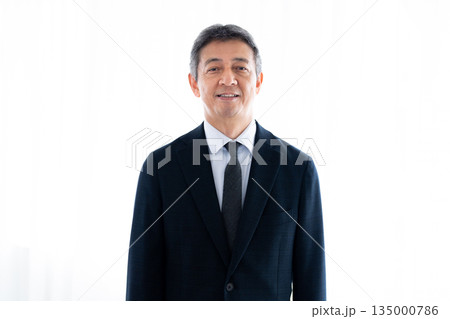 正面を見つめる真剣な表情のシニア男性 135000786