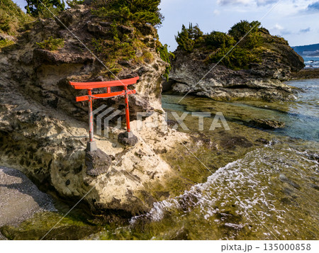 伊豆下田の竜宮島と白嶋神社の赤い鳥居。尾ヶ崎ウイングからドローン撮影。青い海と白い波濤、緑の林。 伊豆下田の竜宮島と白嶋神社の赤い鳥居。尾ヶ崎ウイングからドローン撮影。青い海と白い波濤、緑の林。 135000858