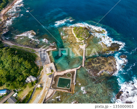 伊豆下田の竜宮島と白嶋神社の赤い鳥居。尾ヶ崎ウイングからドローン撮影。青い海と白い波濤、緑の林。 伊豆下田の竜宮島と白嶋神社の赤い鳥居。尾ヶ崎ウイングからドローン撮影。青い海と白い波濤、緑の林。 135000903