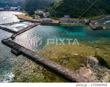 伊豆下田の竜宮島と白嶋神社の赤い鳥居。尾ヶ崎ウイングからドローン撮影。青い海と白い波濤、緑の林。 135000908