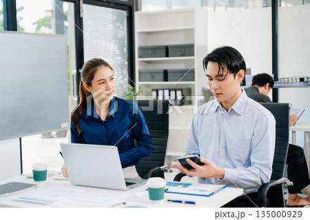 Office colleagues have a casual discussion. During a meeting in a conference room, a group of business teem sit in room new startup project. Office colleagues have a casual discussion. During a meeting in a conference room, a group of business teem sit in room new startup project. 135000929