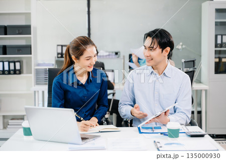 Young Asian professionals collaborating in modern office, discussing business strategy, teamwork, and success. Perfect for corporate, startup 135000930