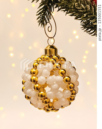 Handmade beaded Christmas ornament hanging on festive tree 135001551