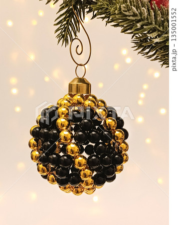 Handmade beaded Christmas ornament hanging on festive tree 135001552