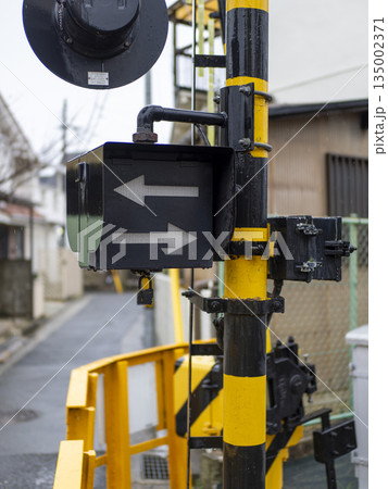 雨に濡れた踏切の警報器 135002371