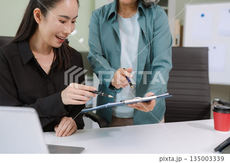 Businessmen team or financial data analysts working with tablets and laptop computers and data graphs together. Plan to analyzing projects in the office. Businessmen team or financial data analysts working with tablets and laptop computers and data graphs together. Plan to analyzing projects in the office. 135003339