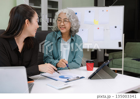 Asian businessman discuss with new startup project Idea presentation, analyze planning and financial statistics and investment market at office. Asian businessman discuss with new startup project Idea presentation, analyze planning and financial statistics and investment market at office. 135003341