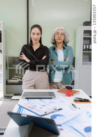 Business team analyzing documents, graphs, and data with a laptop, tablet, and smartphone. Collaboration, strategy, and success. Business team analyzing documents, graphs, and data with a laptop, tablet, and smartphone. Collaboration, strategy, and success. 135003357