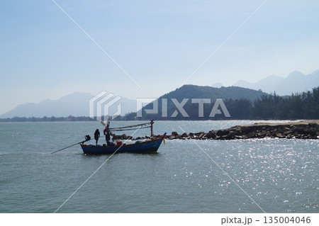 Wooden fisherman's boat at sea.A small, wooden, colorful fisherman's boat returning from fishing to the village. Wooden fisherman's boat at sea.A small, wooden, colorful fisherman's boat returning from fishing to the village. 135004046