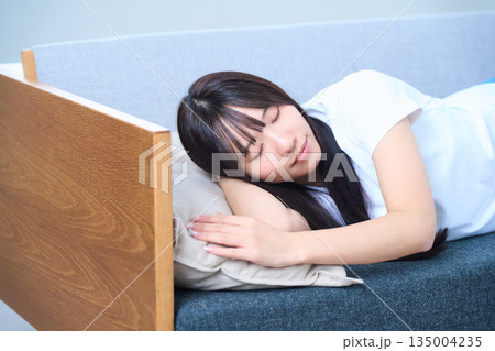 ファで心地よく昼寝をする若い日本人女性 ファで心地よく昼寝をする若い日本人女性 135004235