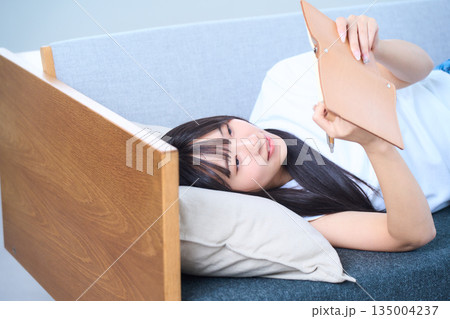ソファで手帳を見る若い日本人女性 135004237