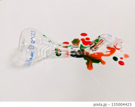 A broken beaker and spilled liquid create a striking visual of a science experiment gone wrong 135004423