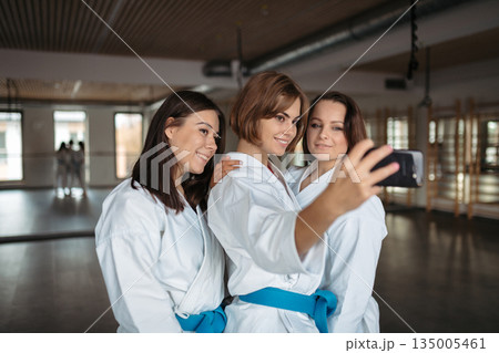 Three karate athletes taking selfie after training. 135005461