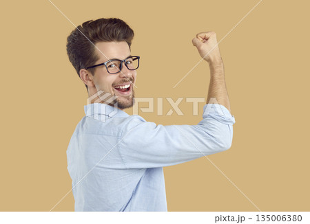 Happy person demonstrates his victory with a raised fist up. 135006380