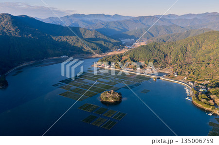 南伊勢町・五ヶ所湾の養殖いかだと山に囲まれた入り江の空撮 南伊勢町・五ヶ所湾の養殖いかだと山に囲まれた入り江の空撮 135006759