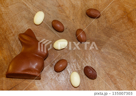 Easter chocolate bunny and chocolate eggs on wooden background. Top view Easter chocolate bunny and chocolate eggs on wooden background. Top view 135007303