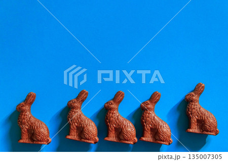 Easter chocolate bunnies on blue background. Top view Easter chocolate bunnies on blue background. Top view 135007305