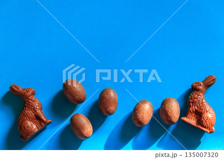 Easter chocolate bunnies and chocolate eggs on blue background. Top view 135007320