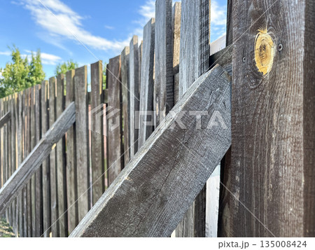 Close-up of a rustic wooden fence outdoors. Close-up of a rustic wooden fence outdoors. 135008424