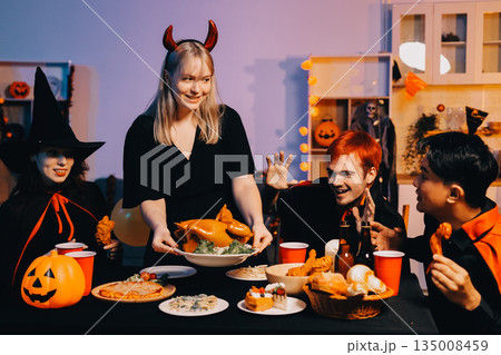 Friends enjoying a Halloween party at a bar making a toast 135008459