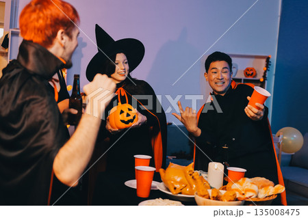 Friends enjoying a Halloween party at a bar making a toast 135008475