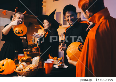 Friends enjoying a Halloween party at a bar making a toast 135008499