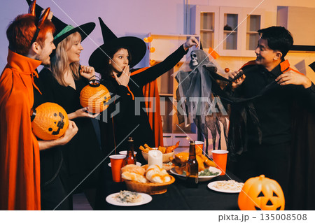 Friends enjoying a Halloween party at a bar making a toast Friends enjoying a Halloween party at a bar making a toast 135008508