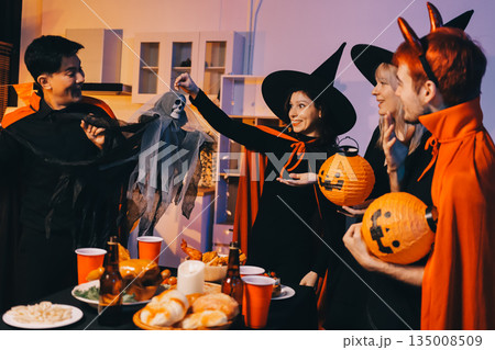 Friends enjoying a Halloween party at a bar making a toast Friends enjoying a Halloween party at a bar making a toast 135008509