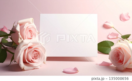 A beautiful bouquet of red roses and a blank paper gift card on a floral background for a romantic Valentine's Day or anniversary celebration 135008656