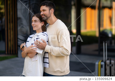 Smiling man and woman standing together and feeling happy Smiling man and woman standing together and feeling happy 135009824