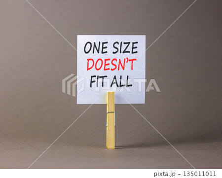 One size does not fit all symbol. Concept words One size does not fit all on beautiful white paper on clothespins. Beautiful grey background. Business one size does not fit all concept. Copy space. 135011011