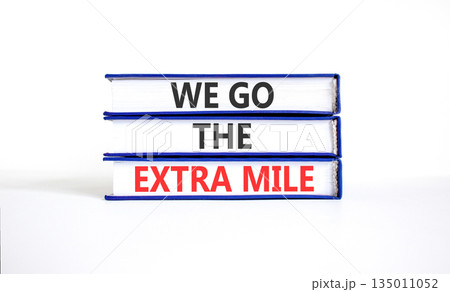 Support, help we go the extra mile symbol. Concept words We go the extra mile on beautiful books. Beautiful white paper background. Business we go the extra mile concept. Copy space. Support, help we go the extra mile symbol. Concept words We go the extra mile on beautiful books. Beautiful white paper background. Business we go the extra mile concept. Copy space. 135011052