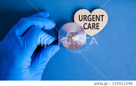 Urgent care symbol. Concept words Urgent care on beautiful wooden heart. Doctor's hand in blue medical glove. Stethoscope. Beautiful blue background. Medical healthy lifestyle urgent care concept. Urgent care symbol. Concept words Urgent care on beautiful wooden heart. Doctor's hand in blue medical glove. Stethoscope. Beautiful blue background. Medical healthy lifestyle urgent care concept. 135011246