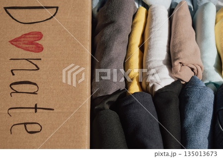 Box filled with neatly folded clothes ready for donation at a local charity for those in need 135013673