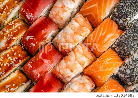Assorted sushi rolls with salmon tuna shrimp and sesame close up Assorted sushi rolls with salmon tuna shrimp and sesame close up 135014698