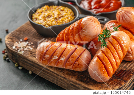 Grilled sausages with spices and sauces on wooden board, close up, copy space Grilled sausages with spices and sauces on wooden board, close up, copy space 135014746