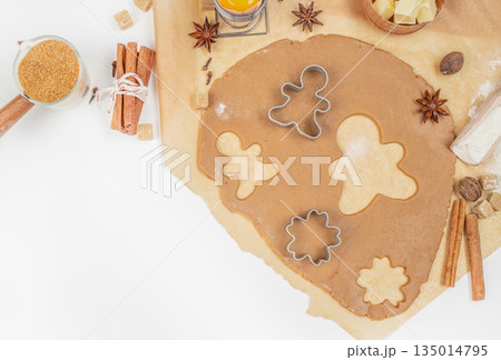 Gingerbread cookie dough with cutters, spices, and ingredients on kitchen table, top view, free space for text 135014795