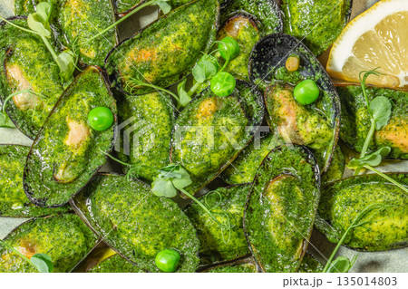 Baked mussels with herbs, green peas, and lemon slices Baked mussels with herbs, green peas, and lemon slices 135014803