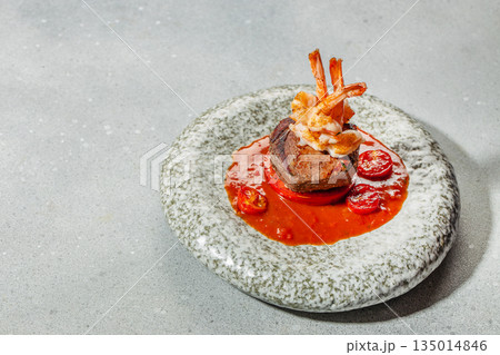Beef steak with grilled shrimp and tomato sauce on a gourmet plate 135014846