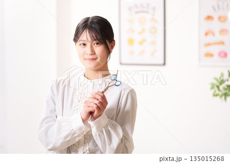 笑顔で視線を向けるヘアスタイリスト 135015268