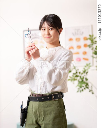 笑顔で視線を向けるヘアスタイリスト 135015270