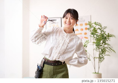 笑顔で視線を向けるヘアスタイリスト 135015271