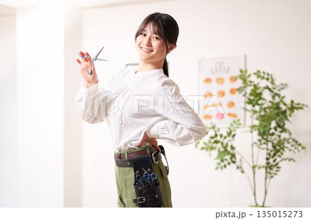 笑顔で視線を向けるヘアスタイリスト 135015273